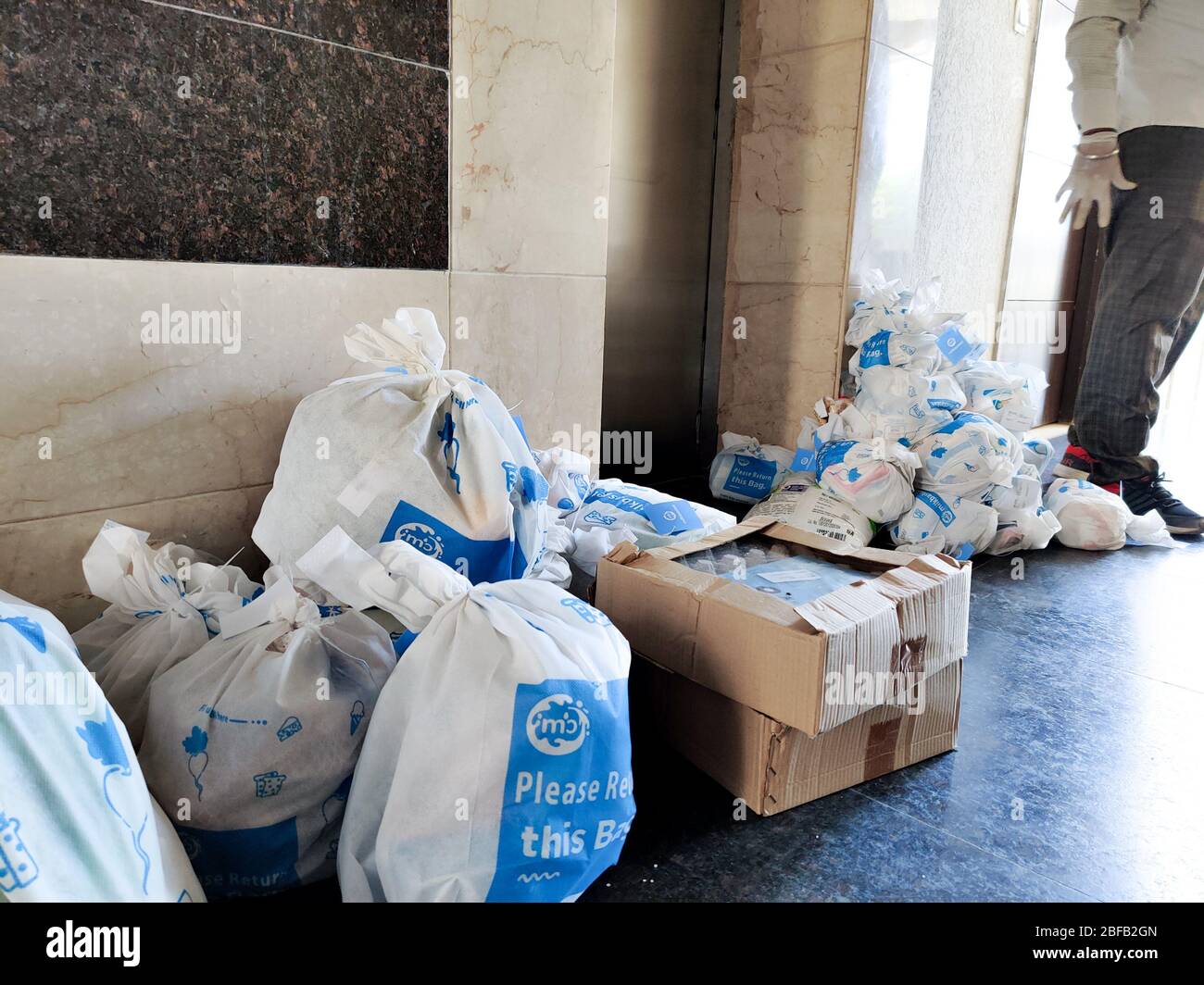 Weiße Beutel mit Milchkorb auf ihnen in der Nähe eines Lifts als Teil der Lieferung in der Wohnung platziert Stockfoto