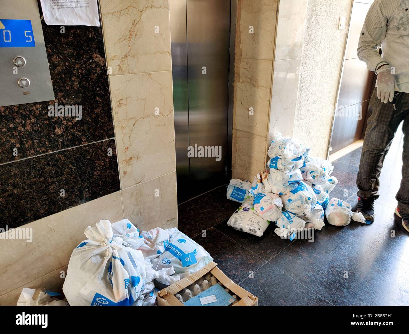 Weiße Beutel mit Milchkorb auf ihnen in der Nähe eines Lifts als Teil der Lieferung in der Wohnung platziert Stockfoto