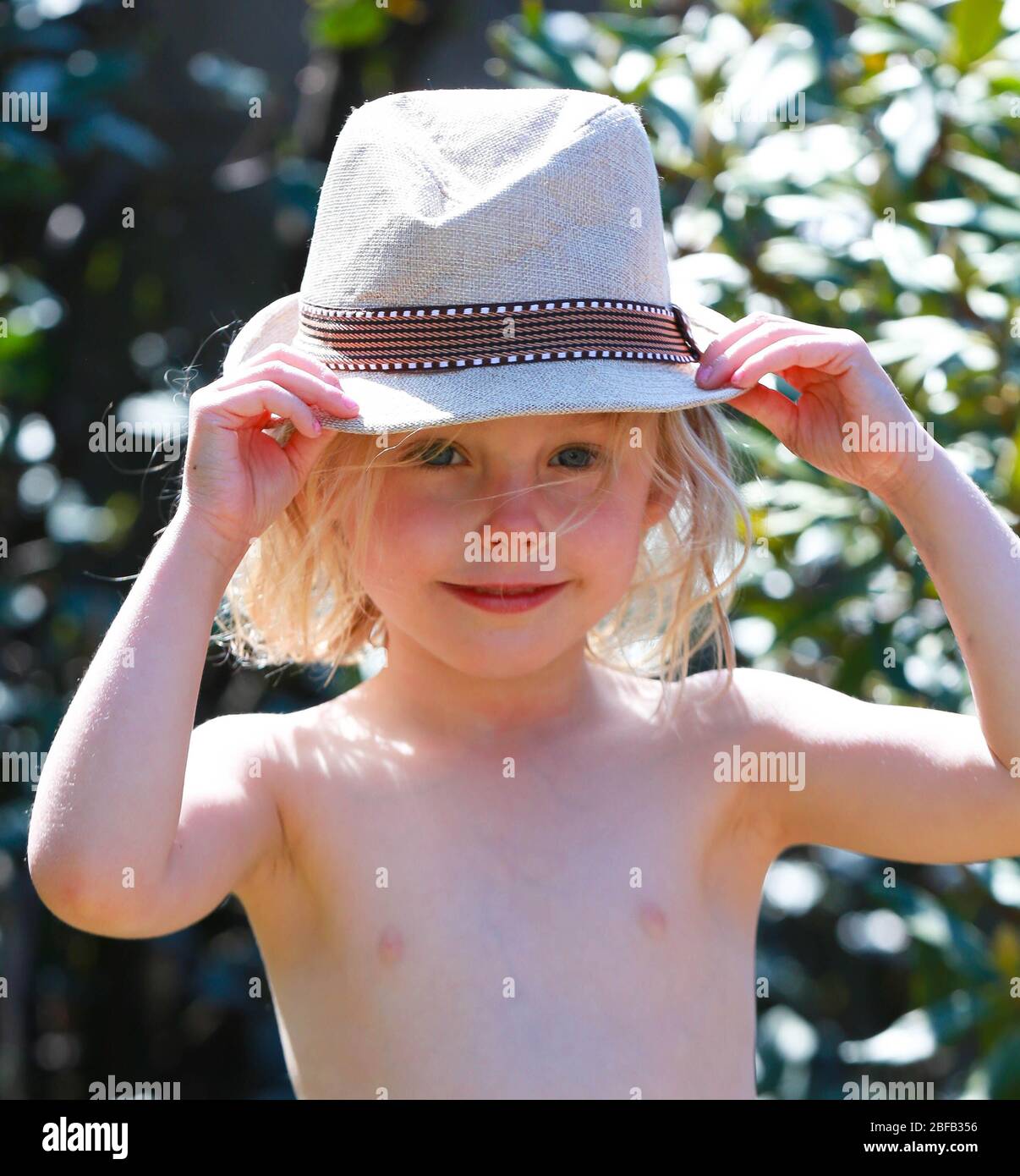 Kleines Kind trägt Hut im Garten Sonnenschein Stockfoto