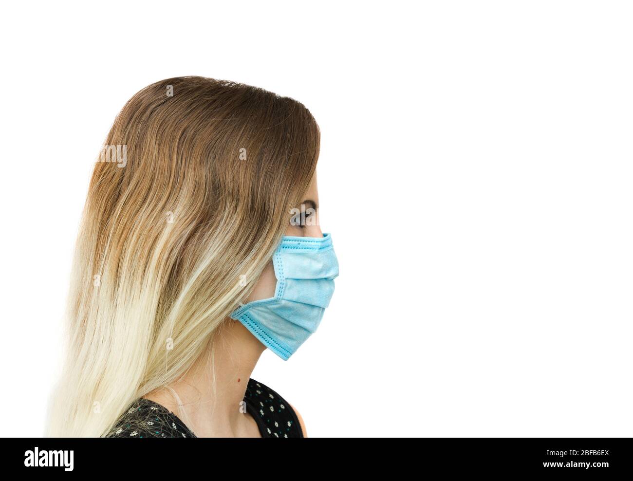 Frau trägt blaue medizinische Maske Seitenansicht sieht nach rechts isoliert auf weiß Stockfoto