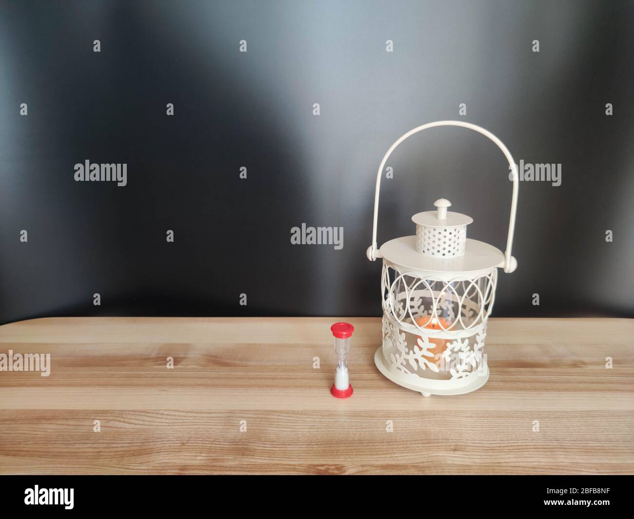 Vintage Laterne mit einer orangen Kerze auf dem Tisch mit schwarzer Kulisse. Konzept - Ramadan kareem Feiertag Feier. Lizenzfreies Stock-Foto Stockfoto
