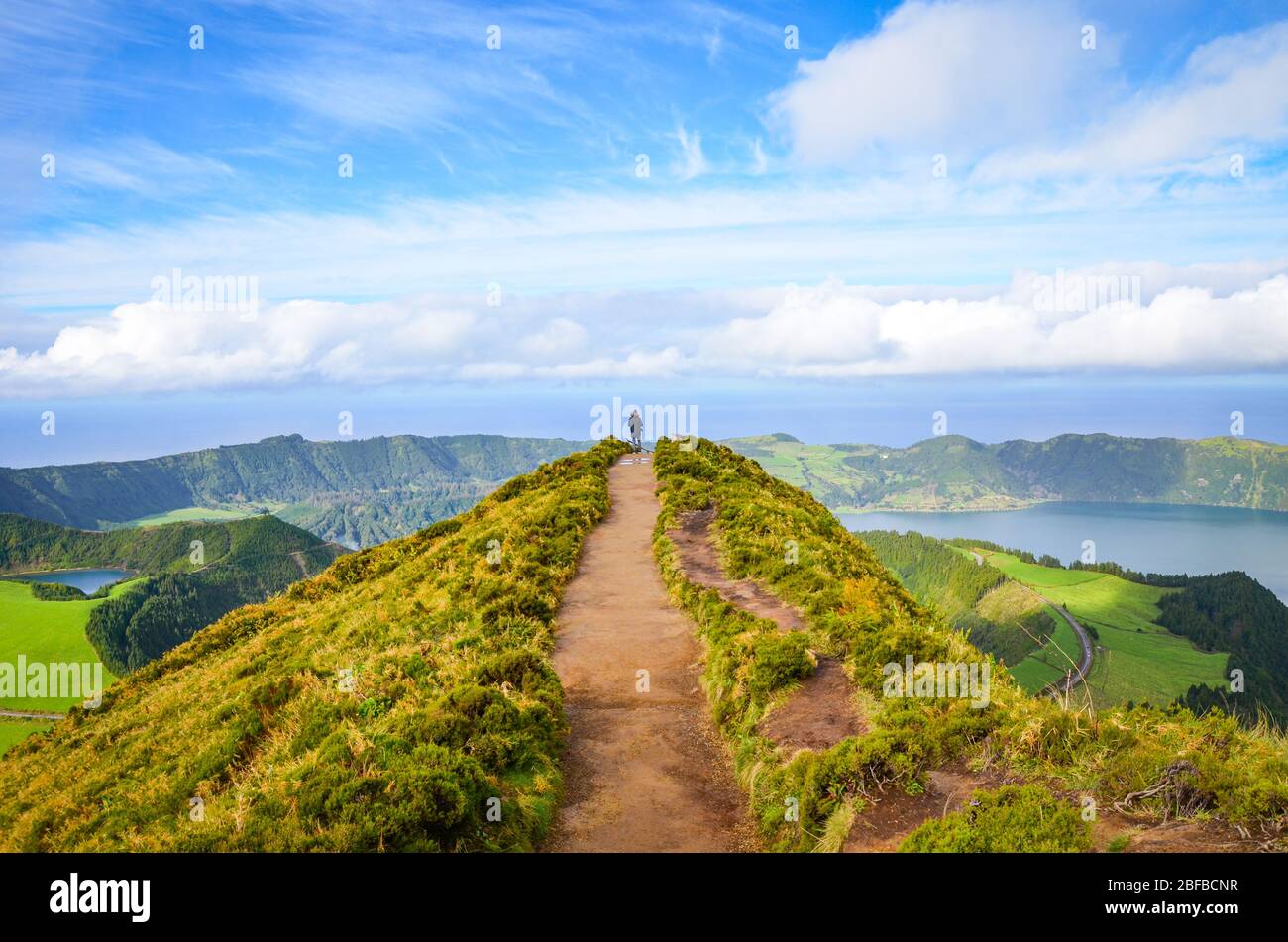 Ein Weg zum Aussichtspunkt Miradouro da Boca do Inferno in Sao Miguel Insel, Azoren, Portugal. Erstaunliche Kraterseen umgeben von grünen Feldern und Wäldern. Tourist am Ende der landschaftlich schönen Weg. Stockfoto