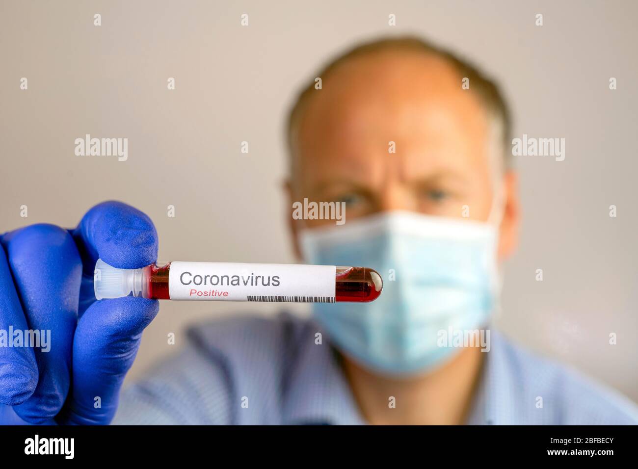 Ein Mann mit Schutzmaske und positivem Ergebnis seines Coronavirus-Tests, Deutschland Stockfoto
