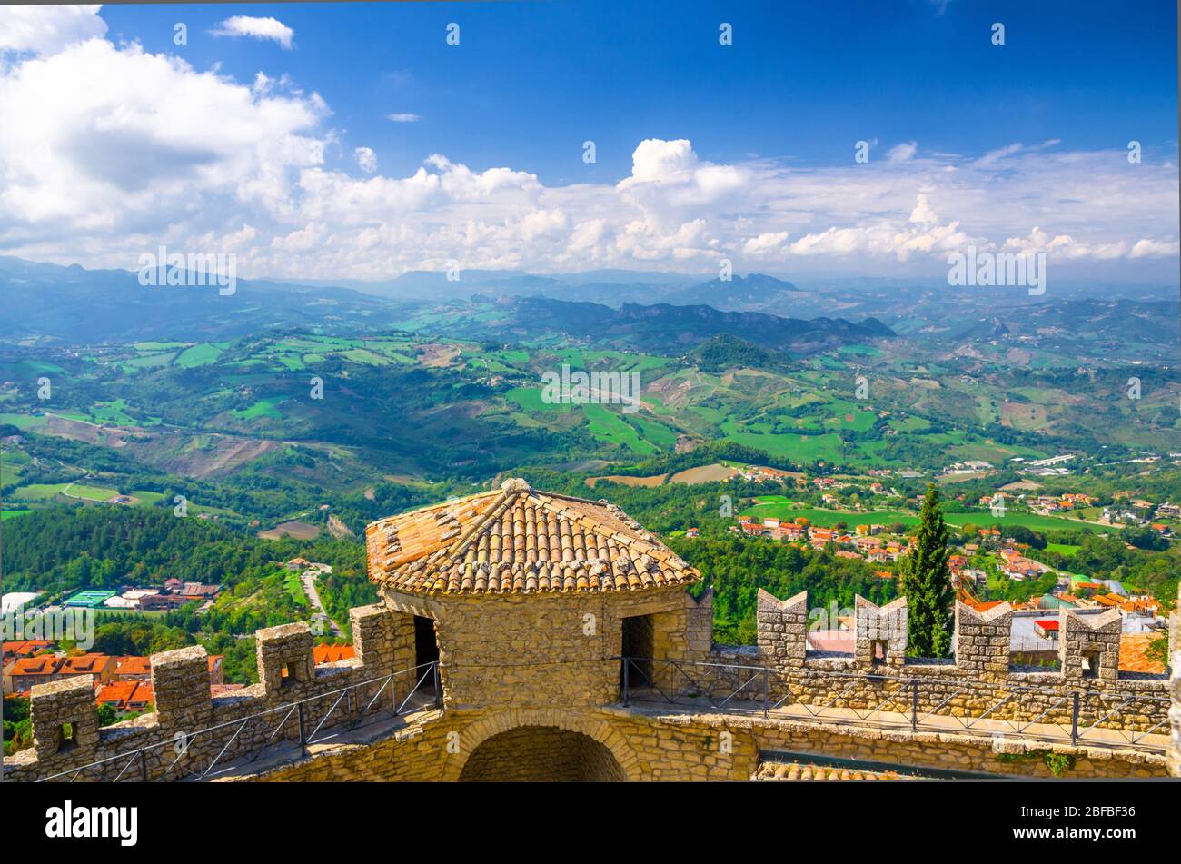 Luftbild oben panoramic view Landschaft mit Tal, grünen Hügeln, Feldern, Dörfern der Republik San Marino Vorstadt, blauen Himmel weißen Wolken zurück gro Stockfoto