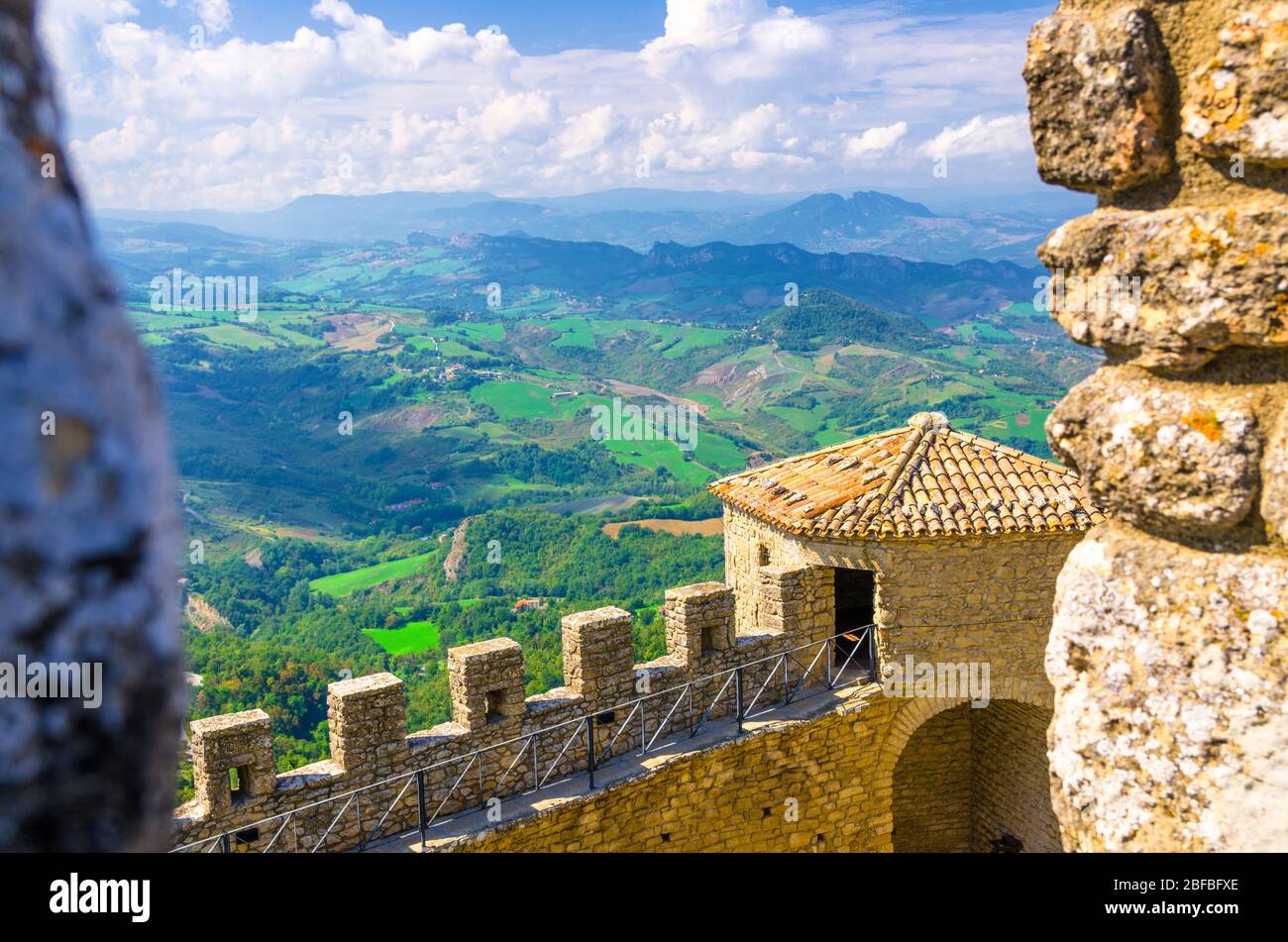 Luftbild oben panoramic view Landschaft mit Tal, grünen Hügeln, Feldern, Dörfern der Republik San Marino Vorstadt, blauen Himmel weißen Wolken zurück gro Stockfoto