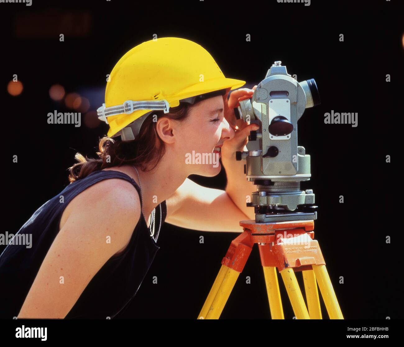 Junge Frau Vermesserin arbeitet mit automatischer Ebene auf der Baustelle, City of London, Greater London, England, Vereinigtes Königreich Stockfoto