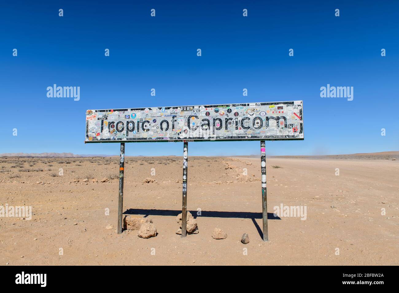 Tropic of Capricorn Schild mit Aufklebern, Etiketten und Graffiti in der offenen Wildnis. Stockfoto