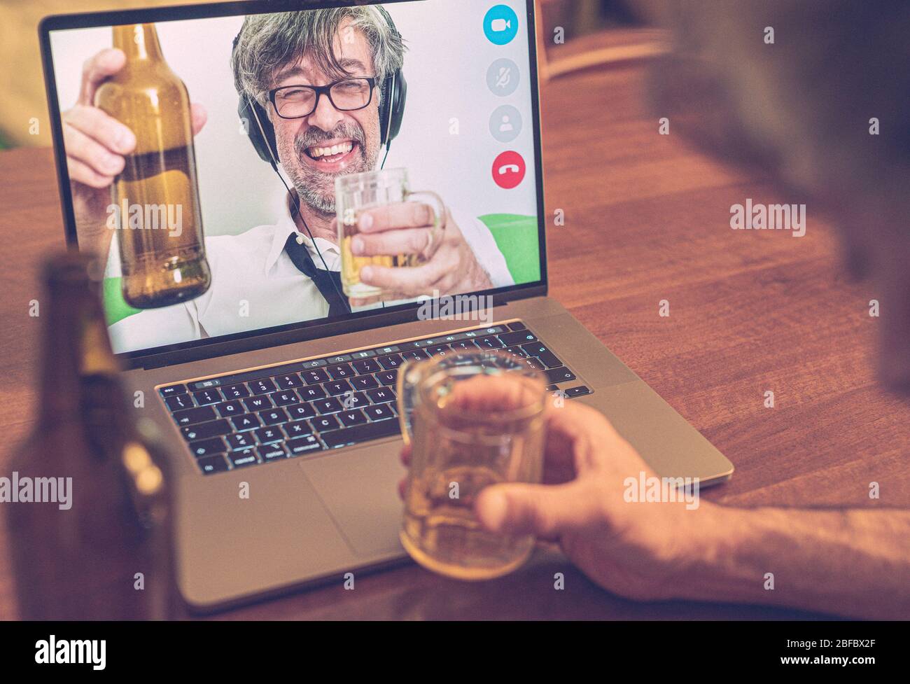 Langjährige Freunde plaudern und trinken Bier bei Videoanrufen feiern Arbeitskollegen einen Erfolg auf der langen Strecke, indem sie sich auf Bier betrinken Stockfoto