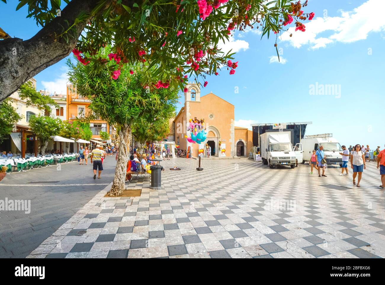 Farbenfrohe Blumen unterstreichen die Piazza Aprile entlang der Hauptstraße Corso Umberto im Ferienort Taormina, Italien, auf der Insel Sizilien. Stockfoto