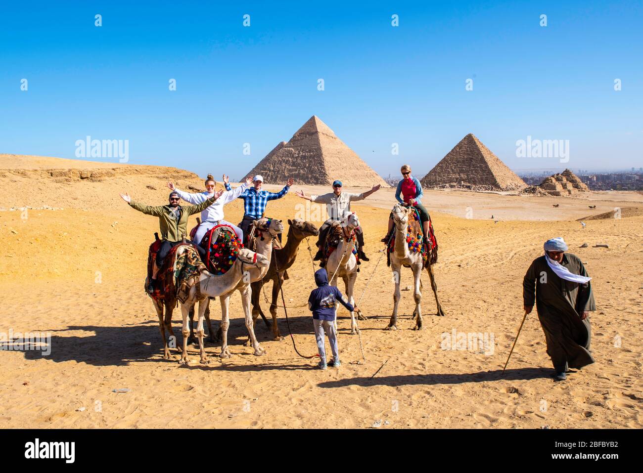 Eine Familie reitet Kamele im Gizeh Pyramid Complex, Gizeh, Ägypten. Stockfoto