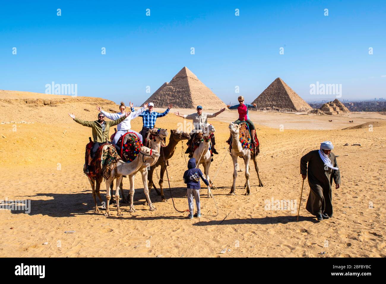 Eine Familie reitet Kamele im Gizeh Pyramid Complex, Gizeh, Ägypten. Stockfoto