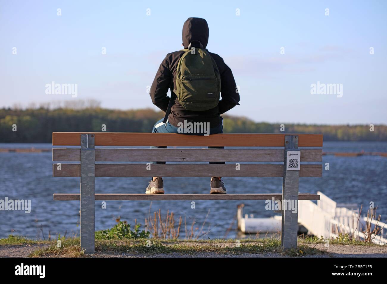 Haltern am See, Deutschland, Samstag 18 April 2020 Mann mit Rucksack allein auf dem Meer Covid-19 Drucke Stockfoto