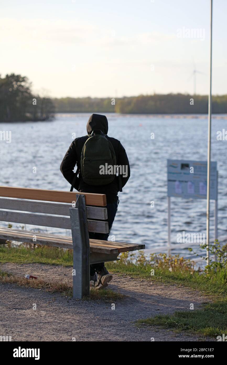 Haltern am See, Deutschland, Samstag 18 April 2020 Mann mit Rucksack allein auf dem Meer Covid-19 Drucke Stockfoto