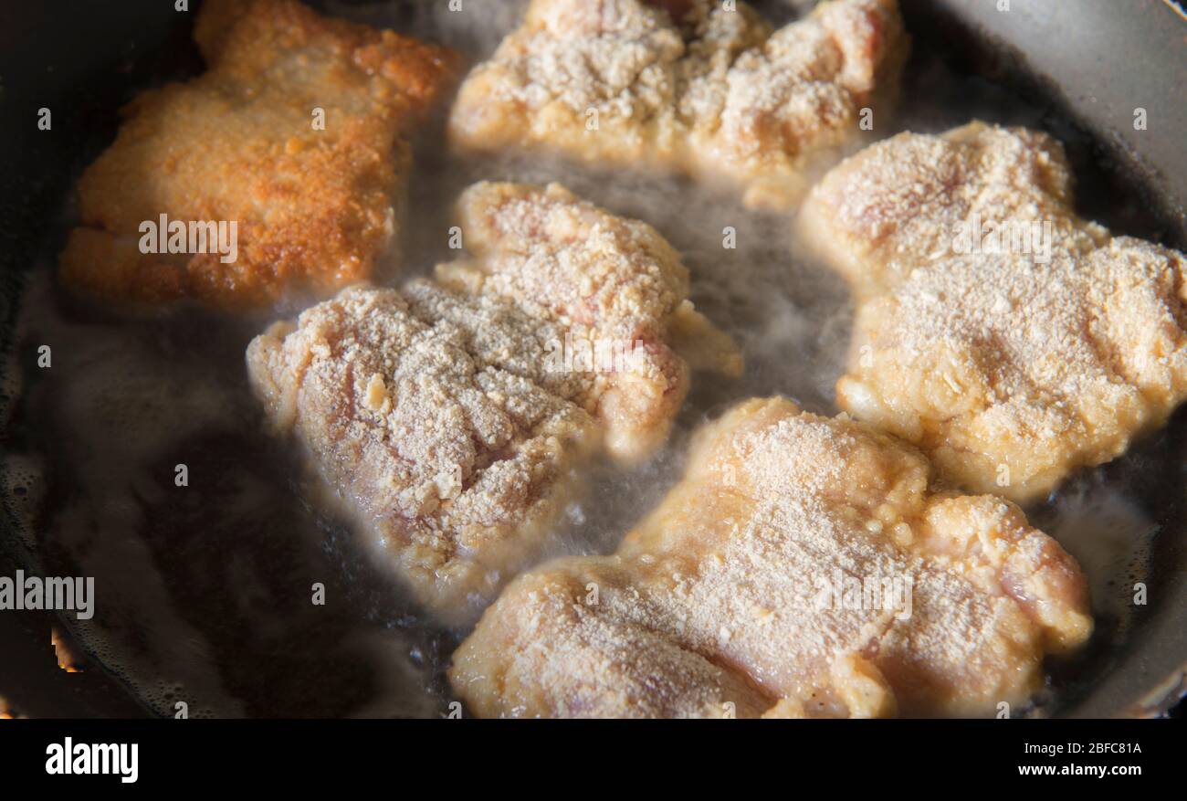 Kochen panierte Huhn in einer Pfanne, hausgemachte Mahlzeit Konzept, ohne Knochen Hähnchenschenkel. Stockfoto
