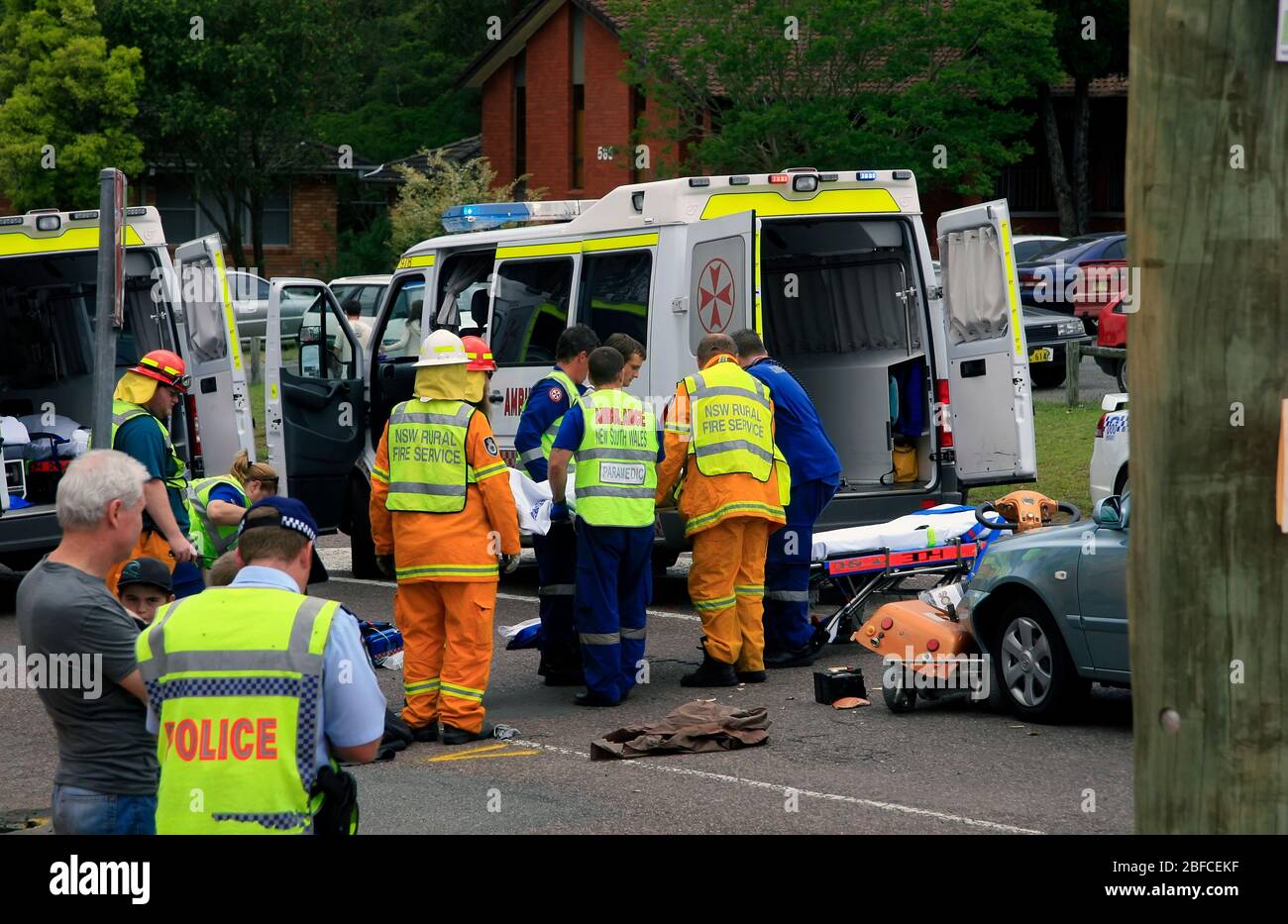 Krankenwagen- und Polizeibeamte beladen einen Unfallpatienten in eine Ambulanz Stockfoto