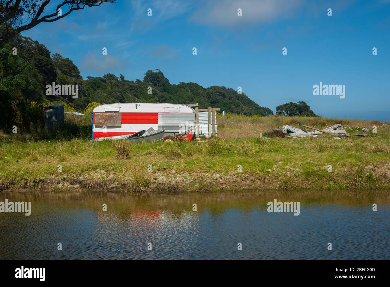 Verlassene alte Wohnwagen neben Bach in Küstenlage. Stockfoto