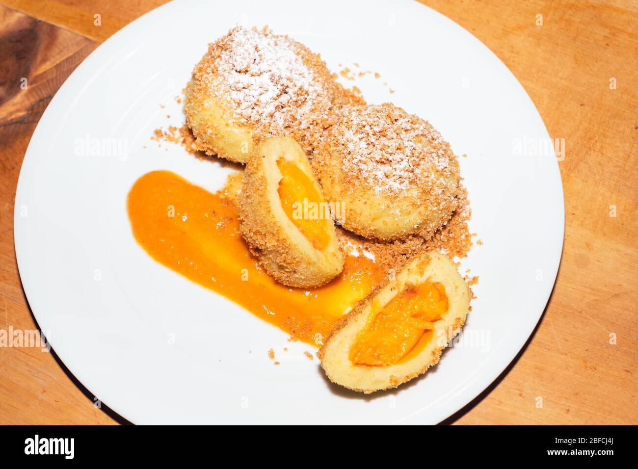 Süße Aprikosen-Knödel mit gebutterten Breadcrumbs auf einem Teller, eine Spezialität der traditionellen österreichischen Küche Stockfoto