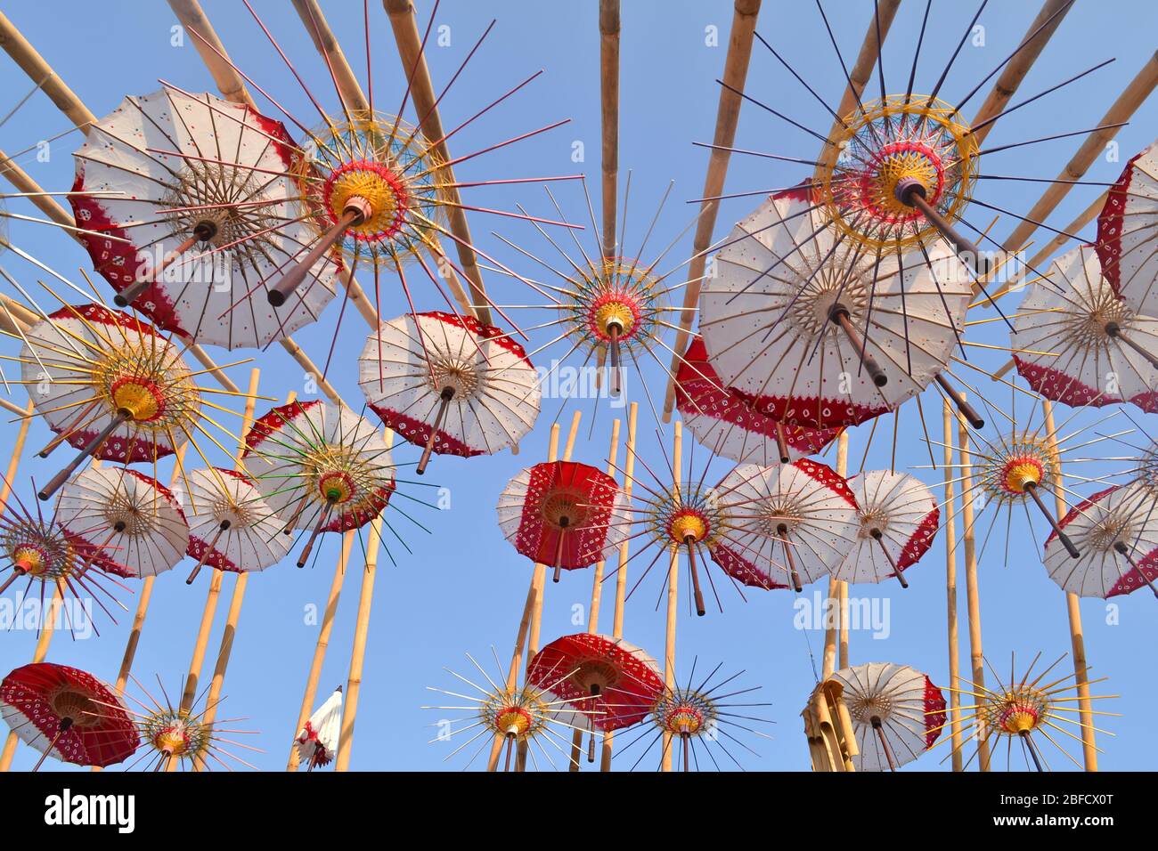 Bunte Regenschirme und Motive hängen in der Luft, Blick von unten. Das Schirmfestival in Solo mit einer Vielzahl von traditionellen und modernen Schirmen. Stockfoto
