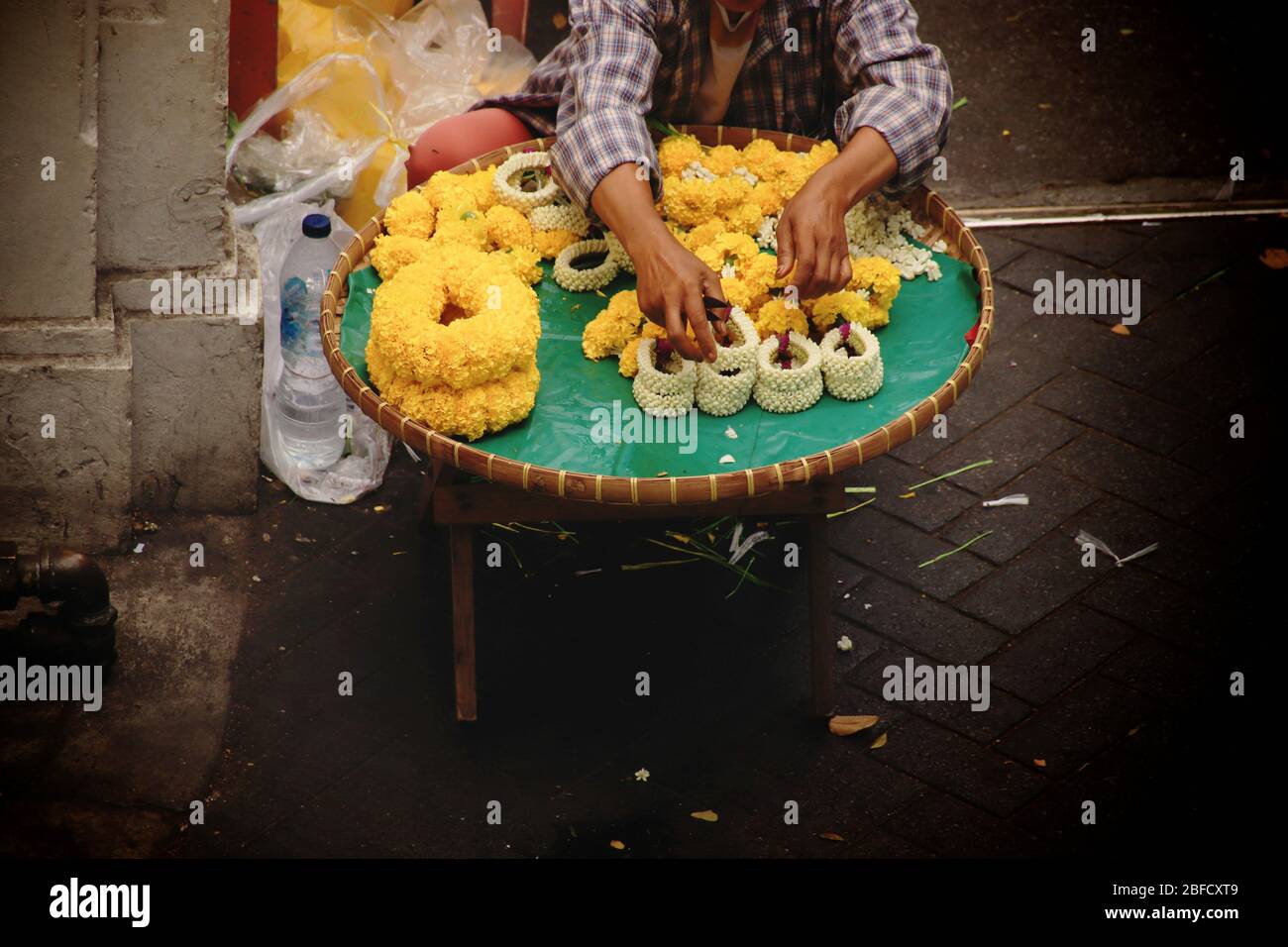 Thailändischer Straßenverkäufer, der Phuang malai oder malai verkauft, eine Blumengirlande, die für buddhistische Opfergaben und Glücksbringer in der thailändischen Kultur verwendet wird Stockfoto
