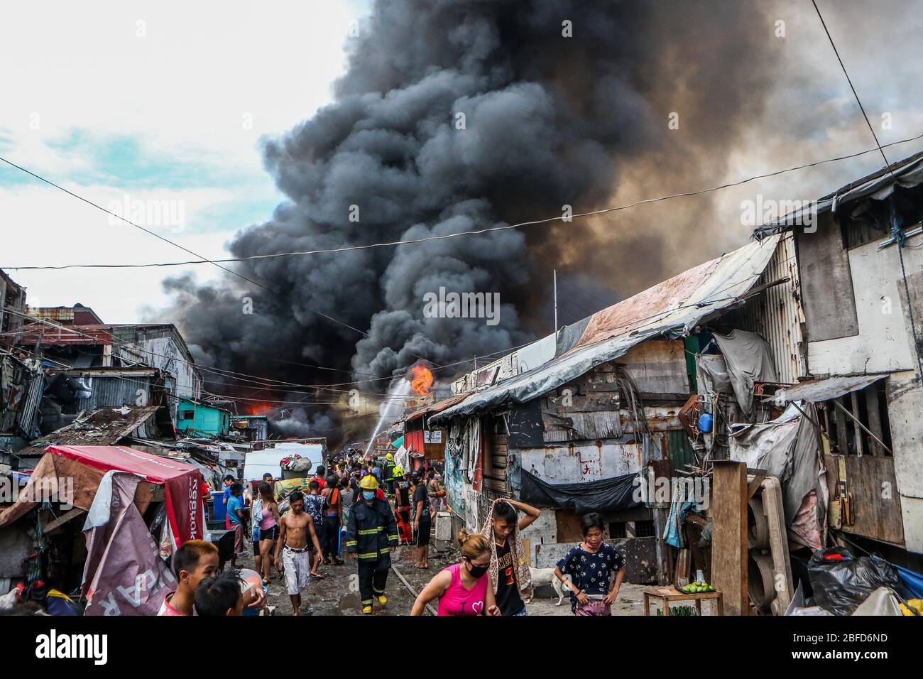 Manila, Philippinen. April 2020. Die Bewohner werden aus einem Brand evakuiert, der ein Slum-Gebiet in Manila, Philippinen, 18. April 2020, verschlingt. Hunderte von Familien wurden am Samstag wegen des Feuers vertrieben. Quelle: Rouelle Umali/Xinhua/Alamy Live News Stockfoto