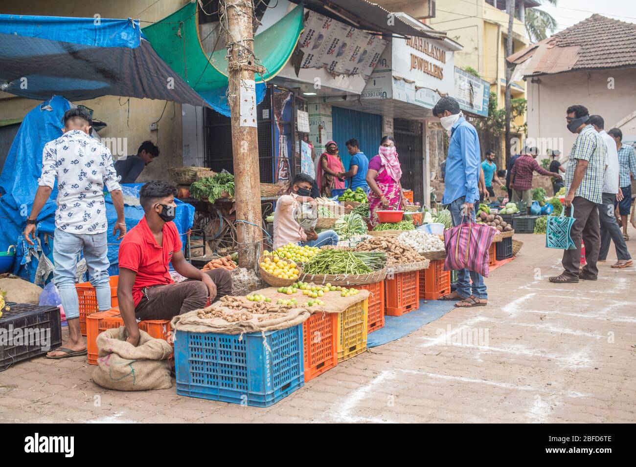 Menschen, die ihren morgendlichen Gemüseeinkauf auf dem ausgewiesenen Marktplatz während der Covid-19 Virus-Sperre in Goa, Indien, machen. Stockfoto