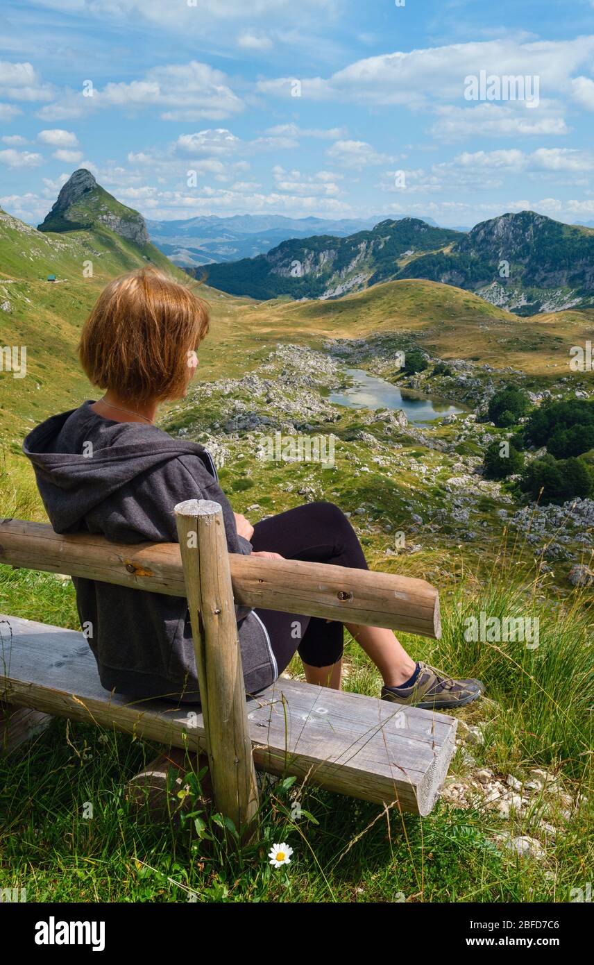 Frau auf Holzbank und malerische Sommer Berglandschaft des Durmitor Nationalpark, Montenegro, Europa, Balkan Dinarischen Alpen, UNESCO World Heri Stockfoto