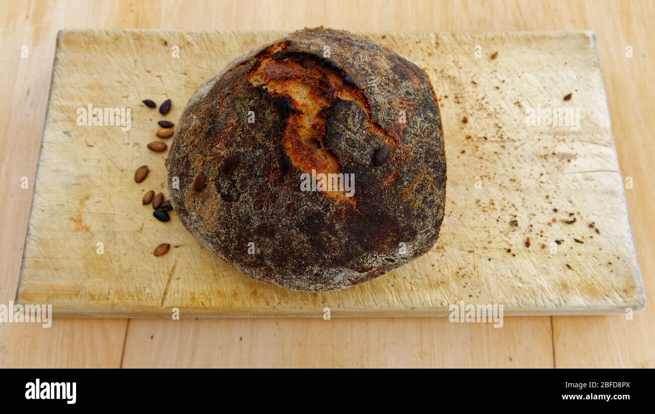 Hausgemachtes Brot sitzt auf einem Brottafel warten, geschnitten zu werden Stockfoto