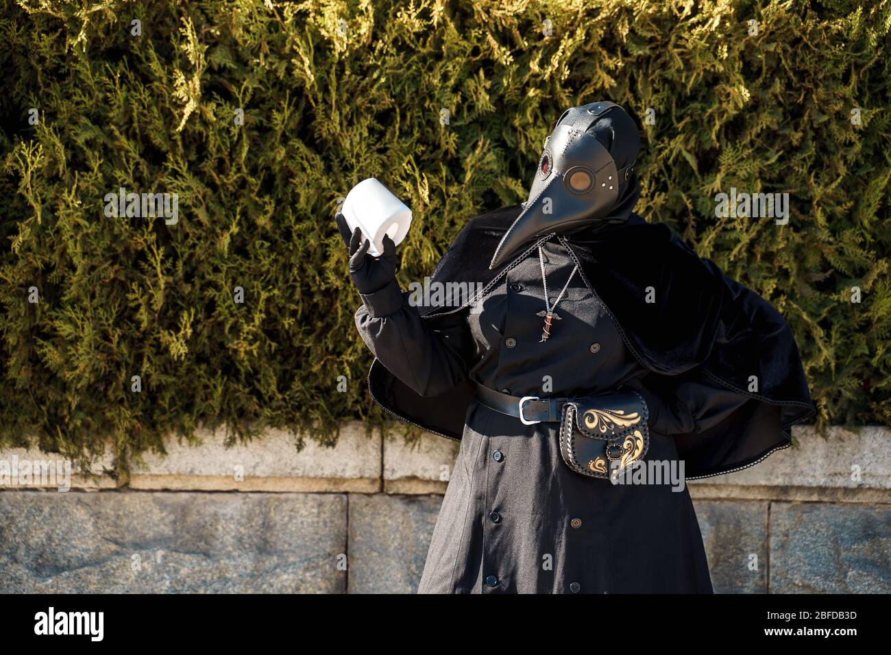 Pest Arzt hält Toilettenpapier auf einem Hintergrund von Pflanzen Stockfoto