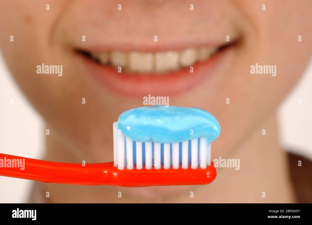 Mann, der Zahnbürste mit Zahnpasta auf ihm vor seinen Zähnen hält -Model  veröffentlicht Stockfotografie - Alamy