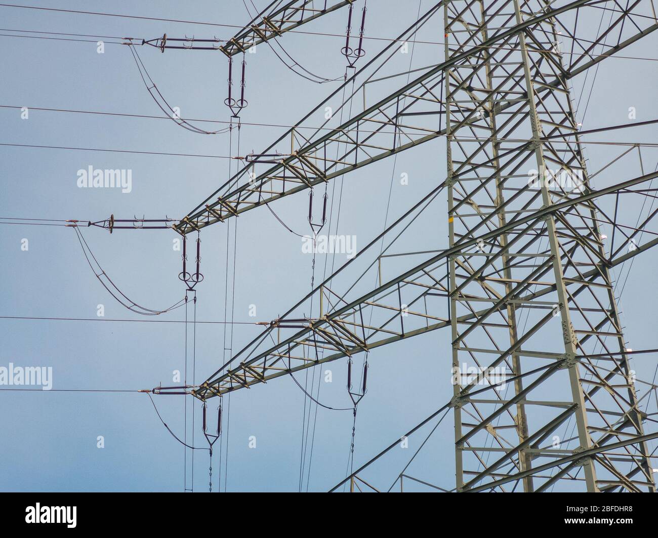 Details eines Masten einer Hochspannungsleitung vor einem blauen Himmel , Elektroindustrie. Stockfoto