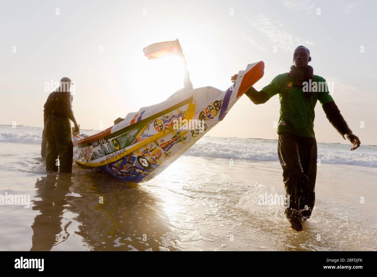 Die Crew-Mitglieder von Mohammed Sovv's Fischfang Pirogue schleppen ihr Boot nach einem Tag lang vor der Küste von Nouakchott, Mauretanien. Stockfoto
