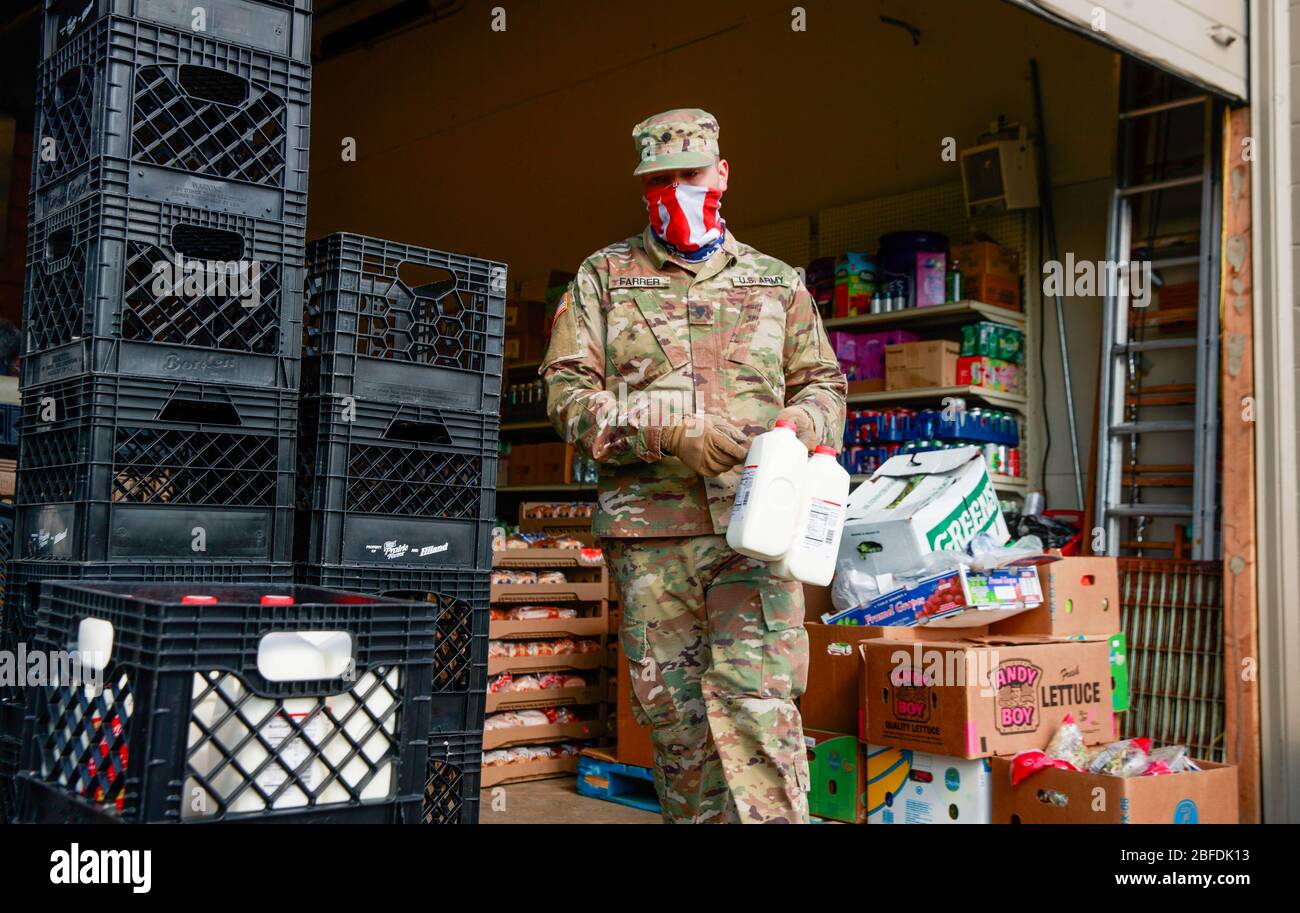 Bloomington, Indiana, USA. April 2020. Ein Mitglied der Indiana National Guard trägt eine amerikanische Flagge Balaclava trägt Nahrung, Heftmilch und Brot in Pantry 279 während die Erfahrung Nahrungsmittelunsicherheit während der COVID-19 / Coronavirus Aufenthalt-at-Home-Bestellung. Quelle: Jeremy Hogan/SOPA Images/ZUMA Wire/Alamy Live News Stockfoto