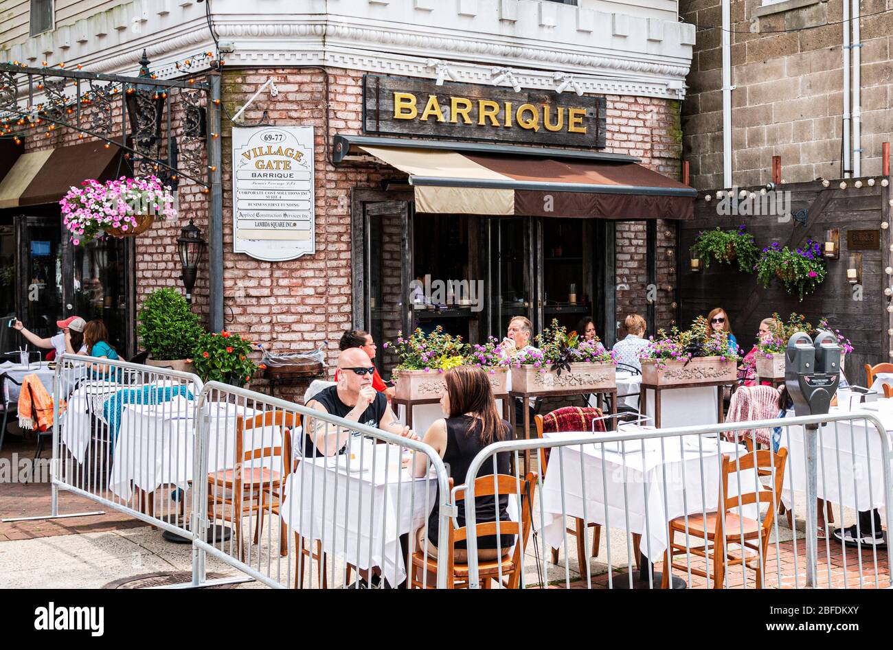 Babylon, New York, USA - 1. Juni 2019: Kunden sitzen und essen draußen an Tischen, die vor dem Barrique in Babylon Dorf duri auf der Straße stehen Stockfoto