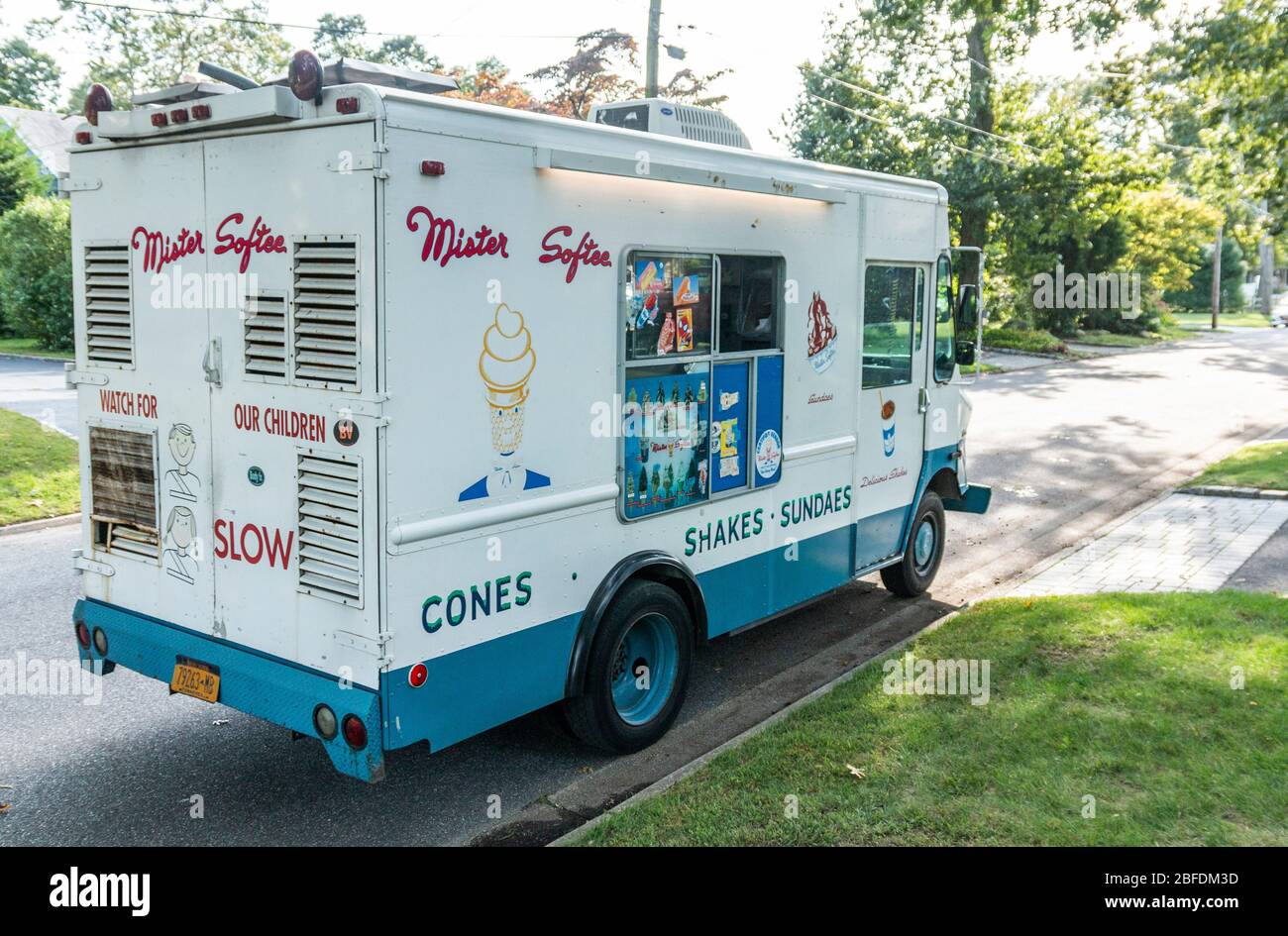 Babylon, New York, USA - 30. September 2018: Ein LKW von Mister Softee fährt eine Straße in einem Wohnviertel entlang und verkauft Eis und Shakes. Stockfoto