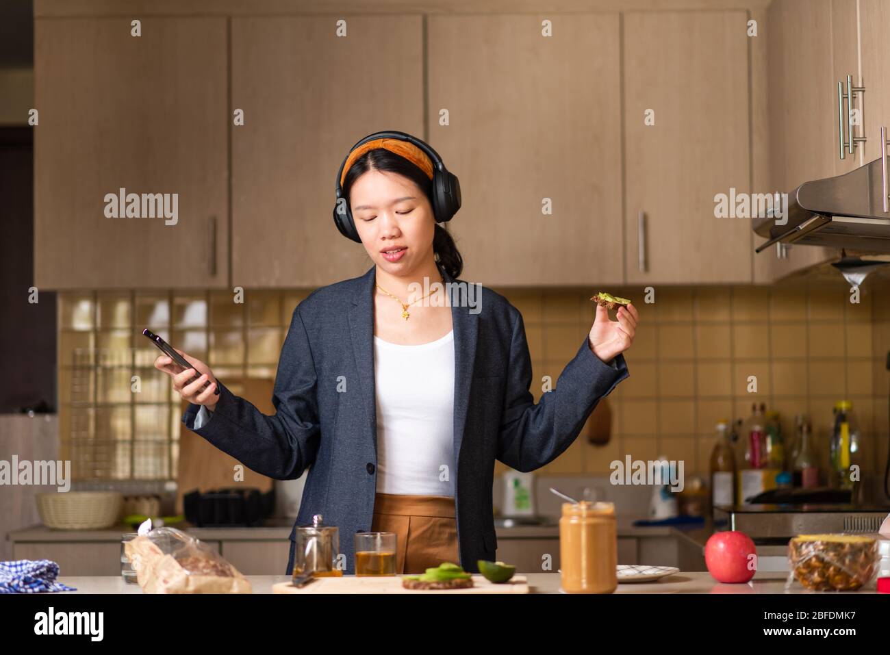 Fröhliche Frau, die in der Küche herumtöricht, nachdem sie zu viel Zeit drinnen verbracht hat Stockfoto