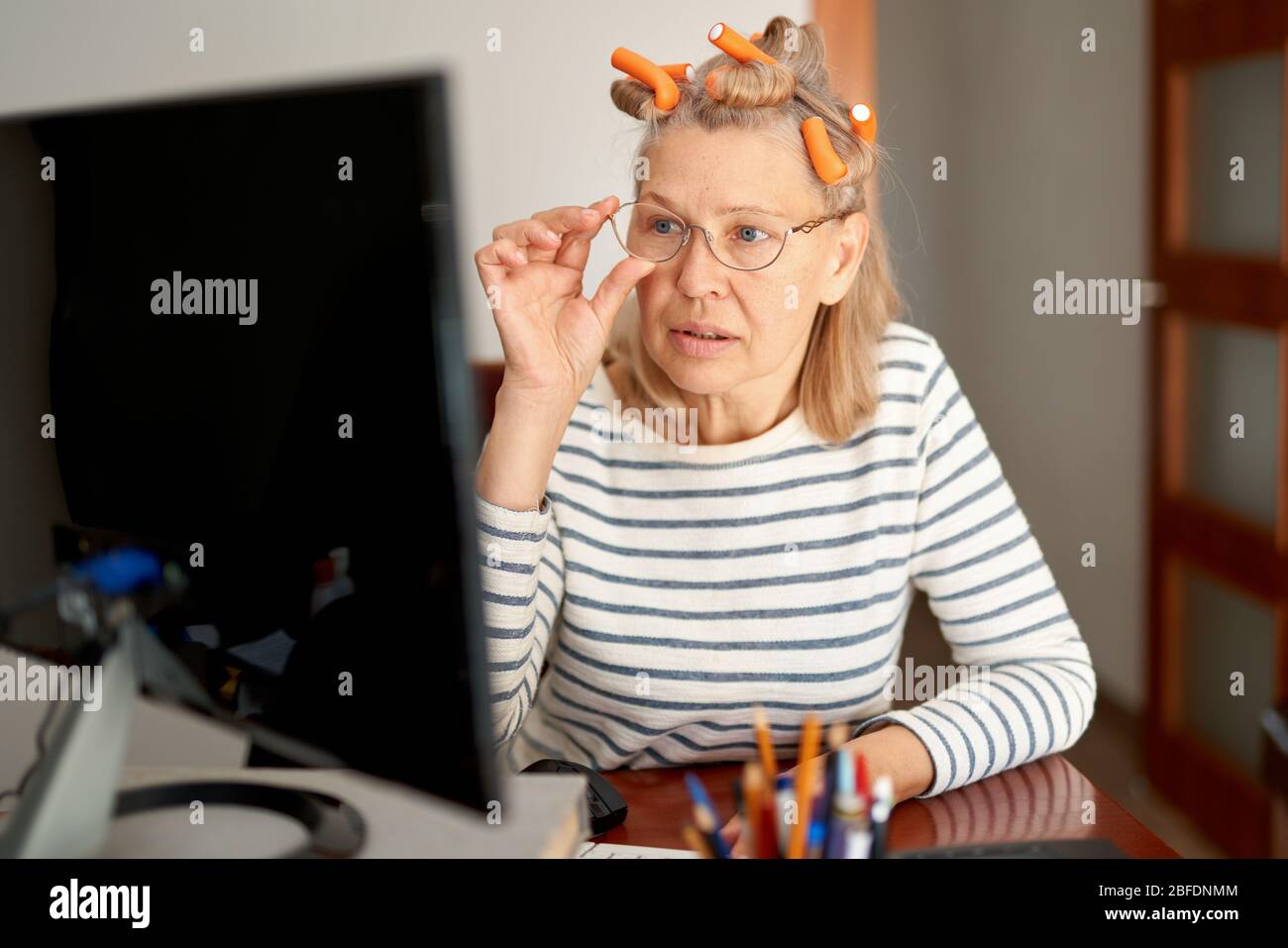 Rentner mittleren Alters in der Brille mit Laptop Eingabe E-Mail arbeiten im Home Office. Stockfoto