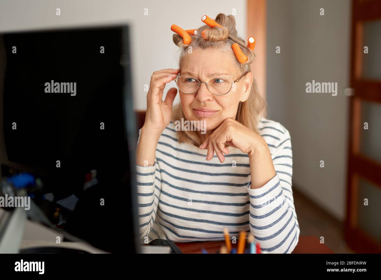 Rentner mittleren Alters in der Brille mit Laptop Eingabe E-Mail arbeiten im Home Office. Stockfoto