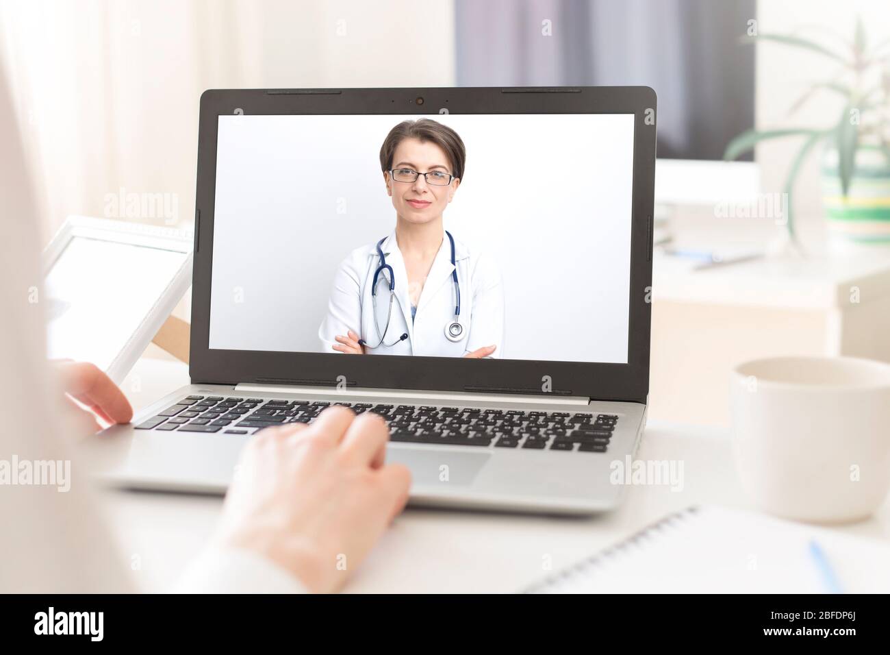 Porträt einer lächelnden Ärztin, die Patienten per Videoanruf im Online-Chat auf dem Computer berät. Stockfoto