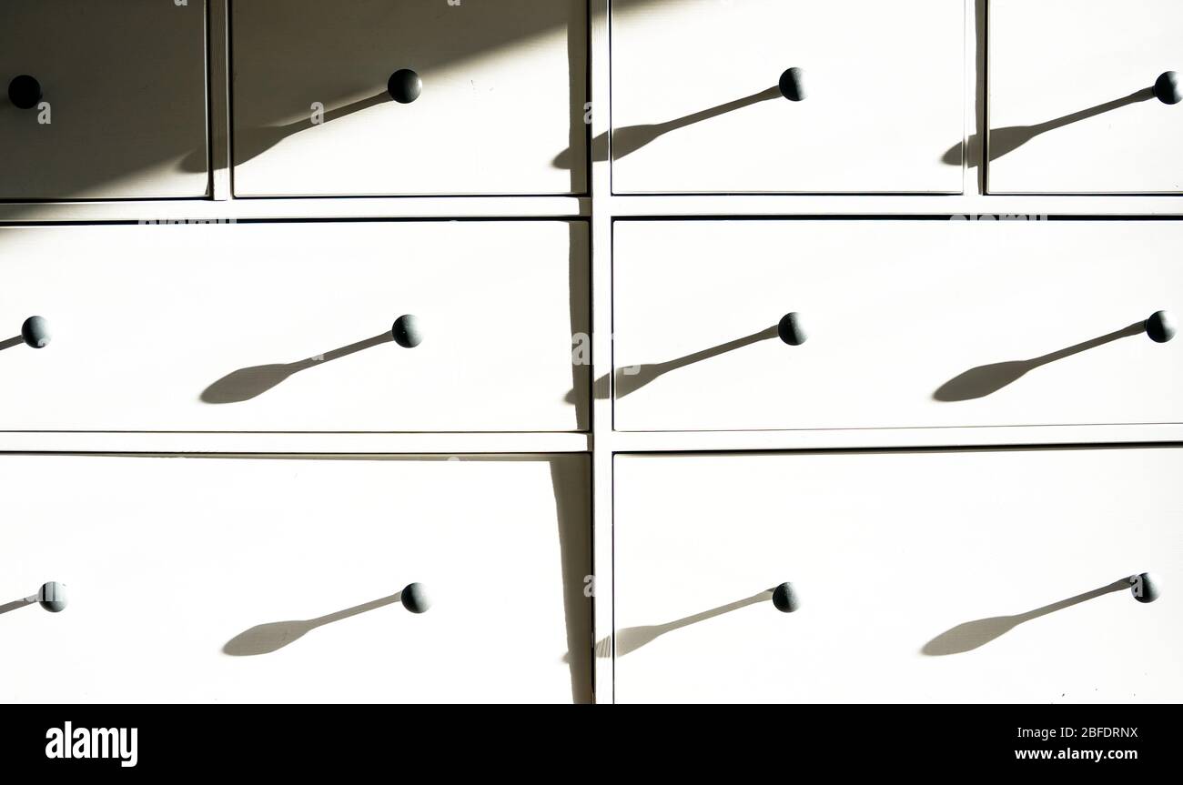 Weiße Kommode mit schwarzen Griffen und scharfen Kontrastschattierungen,  Teil der Inneneinrichtung Stockfotografie - Alamy