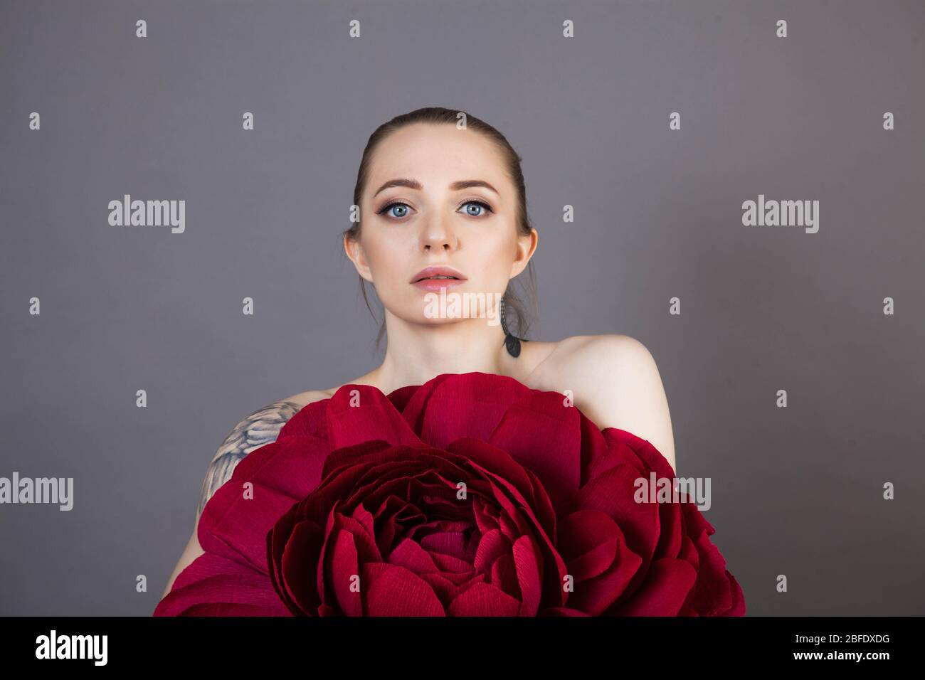 Schönes Mädchen mit gesunder Haut entspannt nach einer Spa-Behandlung mit einer roten Blume Stockfoto