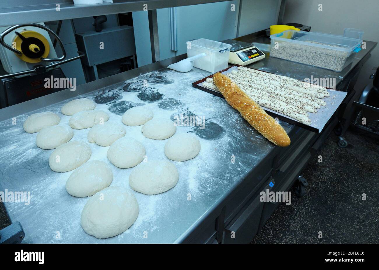 In der Bäckerei: Geformter und bemehlter Teig auf den Arbeitstisch gelegt Stockfoto