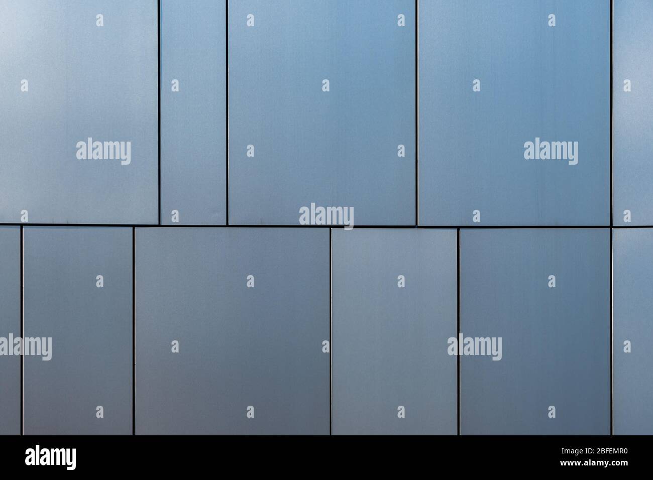 Fassadenverkleidung aus Edelstahl, die in verschiedenen Grau- und Blautönen der Bauelemente erstrahlt Stockfoto