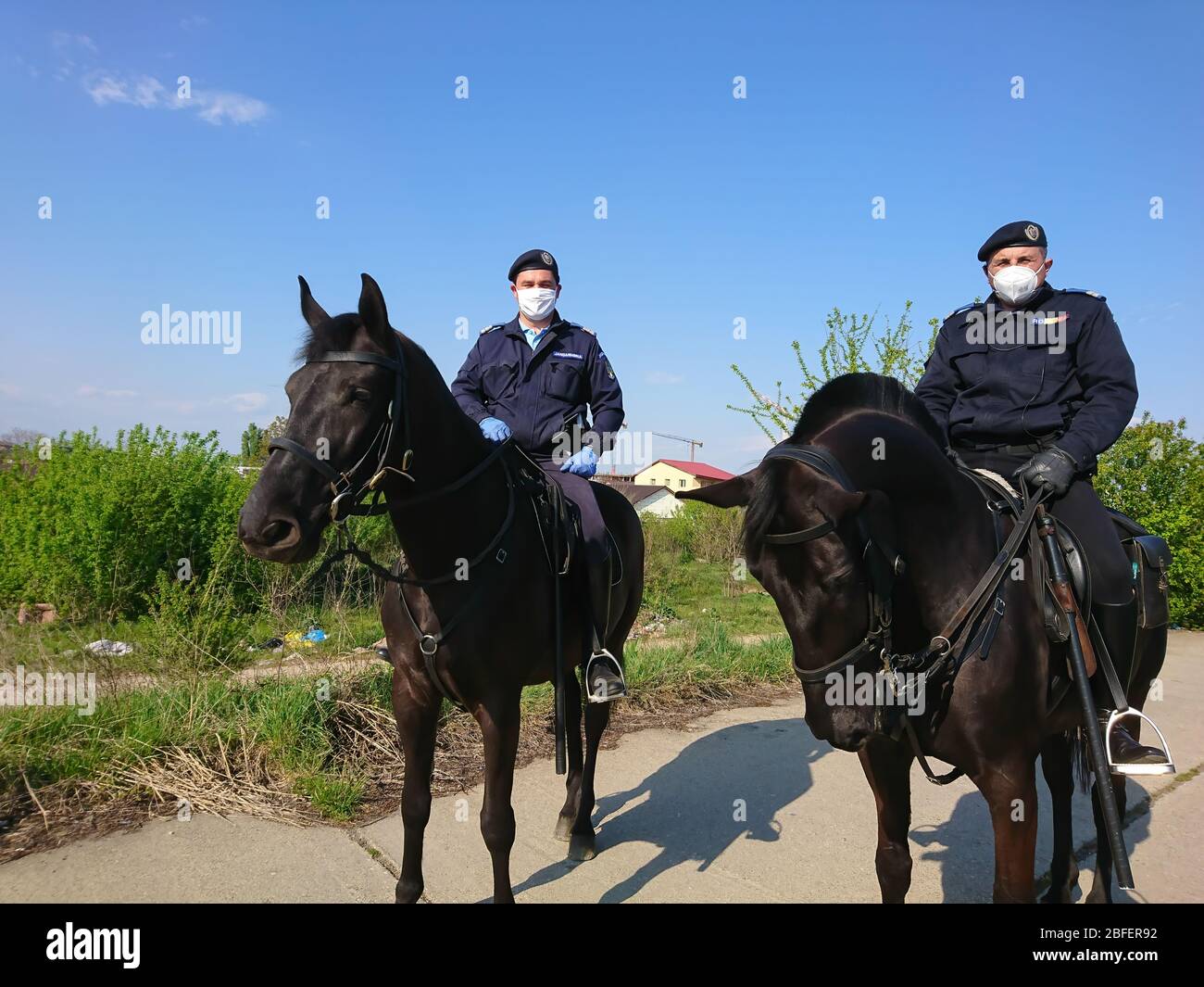Bukarest/Rumänien - 04.18.2020: Die rumänische Gendarmerie auf Pferden mit Gesichtsmasken . Polizei auf Patrouille sicherzustellen, dass das Gesetz durch die Emergenc auferlegt Stockfoto