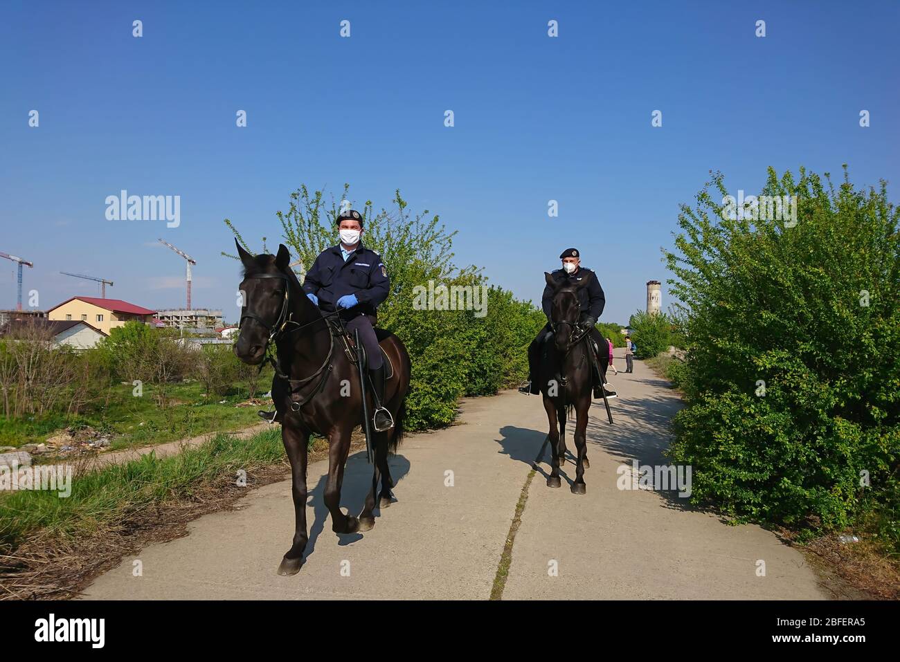 Bukarest/Rumänien - 04.18.2020: Die rumänische Gendarmerie auf Pferden mit Gesichtsmasken . Polizei auf Patrouille sicherzustellen, dass das Gesetz durch die Emergenc auferlegt Stockfoto