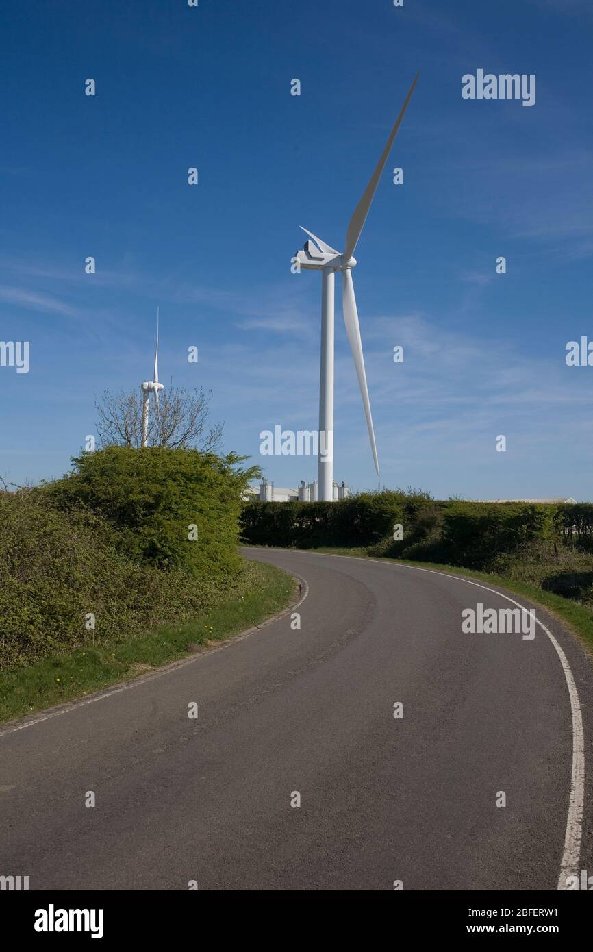 Zwei der Strom erzeugenden Windkraftanlagen stürmen auf dem Boden, dem Gelände eines stillgehaltenen Flugplatzes Stockfoto