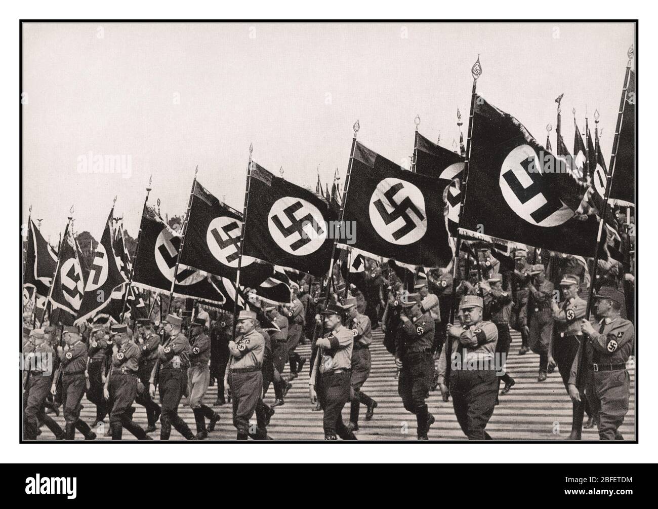 Sturmabteilung SA Truppen Vintage Nazi Deutsch Sturmabteilung SA Truppen marschieren mit Nazi Swastika Flaggen bei Nazi Rallye Nürnberg Deutschland 1933. Als Hauptcover für Propagandafilm 'Triumph des Willens' von Leni Riefenstahl Stockfoto