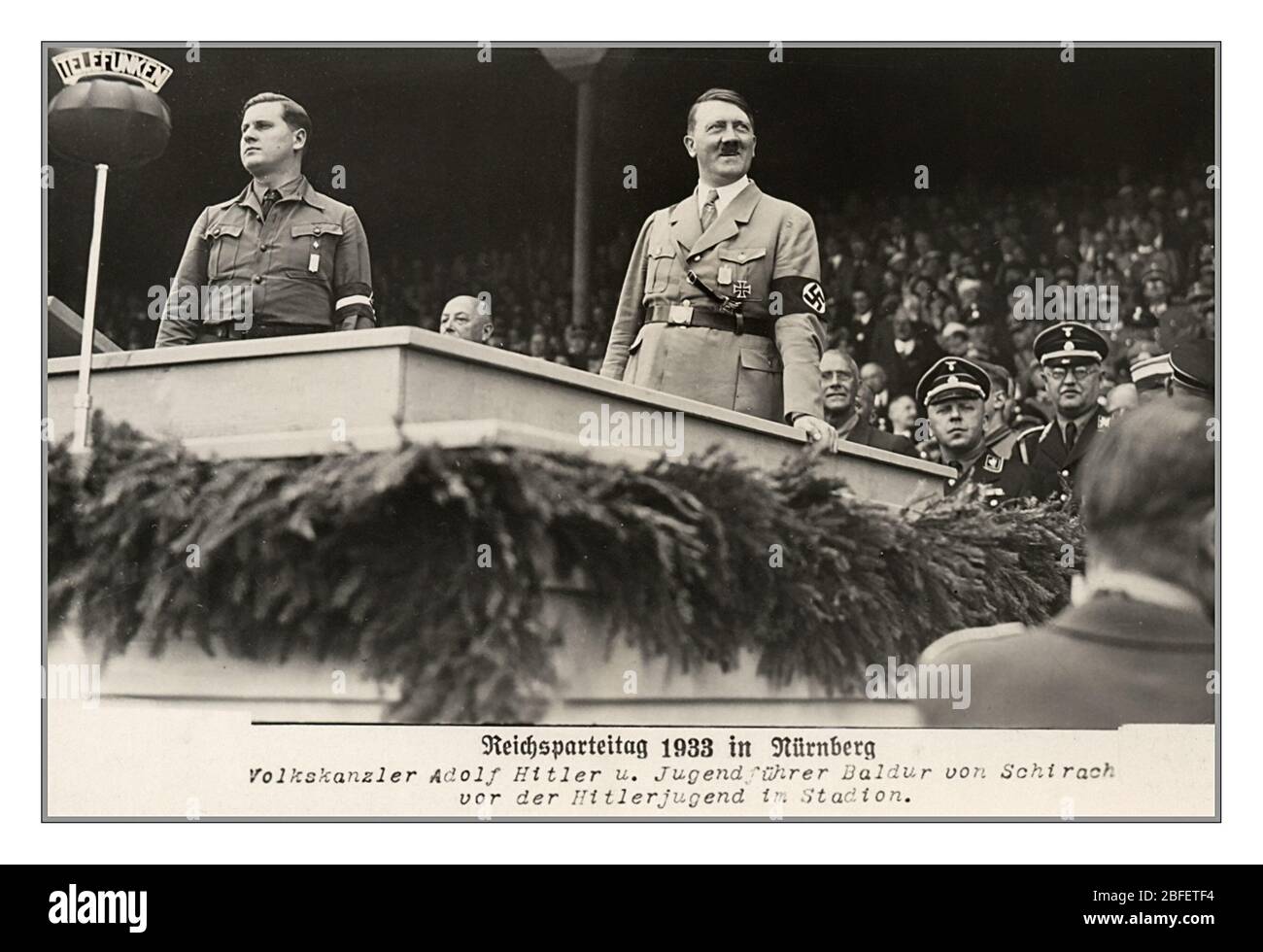 Adolf Hitler Reichsparteitag 1933 Archiv Propaganda Vintage Foto von Menschen Kanzler Adolf Hitler in Militäruniform mit Hakenkreuz-Armband und Jugendführer Baldur von Schirach vor dem Hitler Jugend im Stadion Reichsparteitag 1933 in Nürnberg Nazi-Deutschland Stockfoto