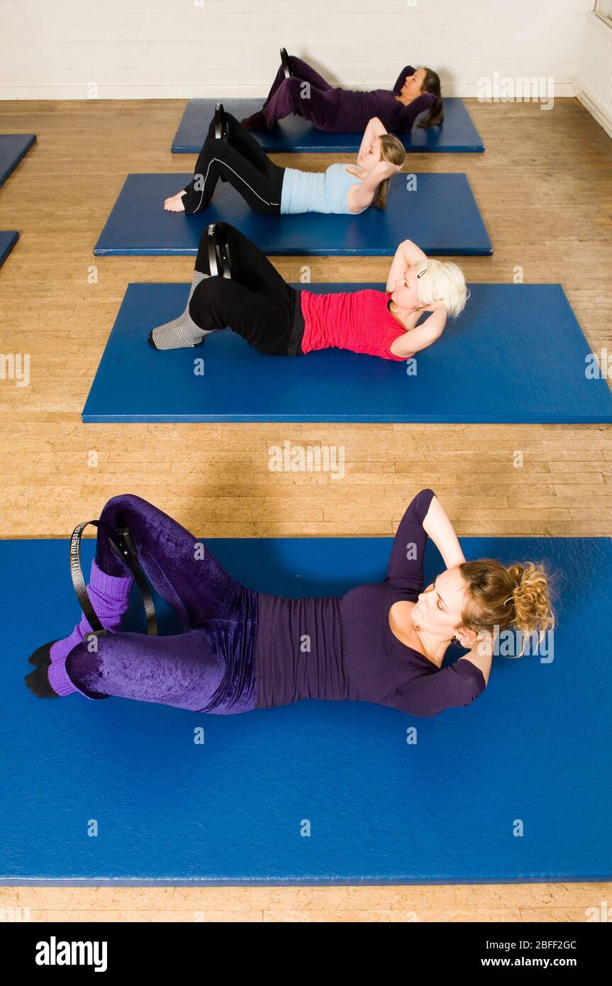 Ein Trainingskurs im Body Control Center in London Üben Sie eine Pilates Curl Up Position mit einem inneren Oberschenkel quetschen Fitness-Ring. Pilates ist Th Stockfoto