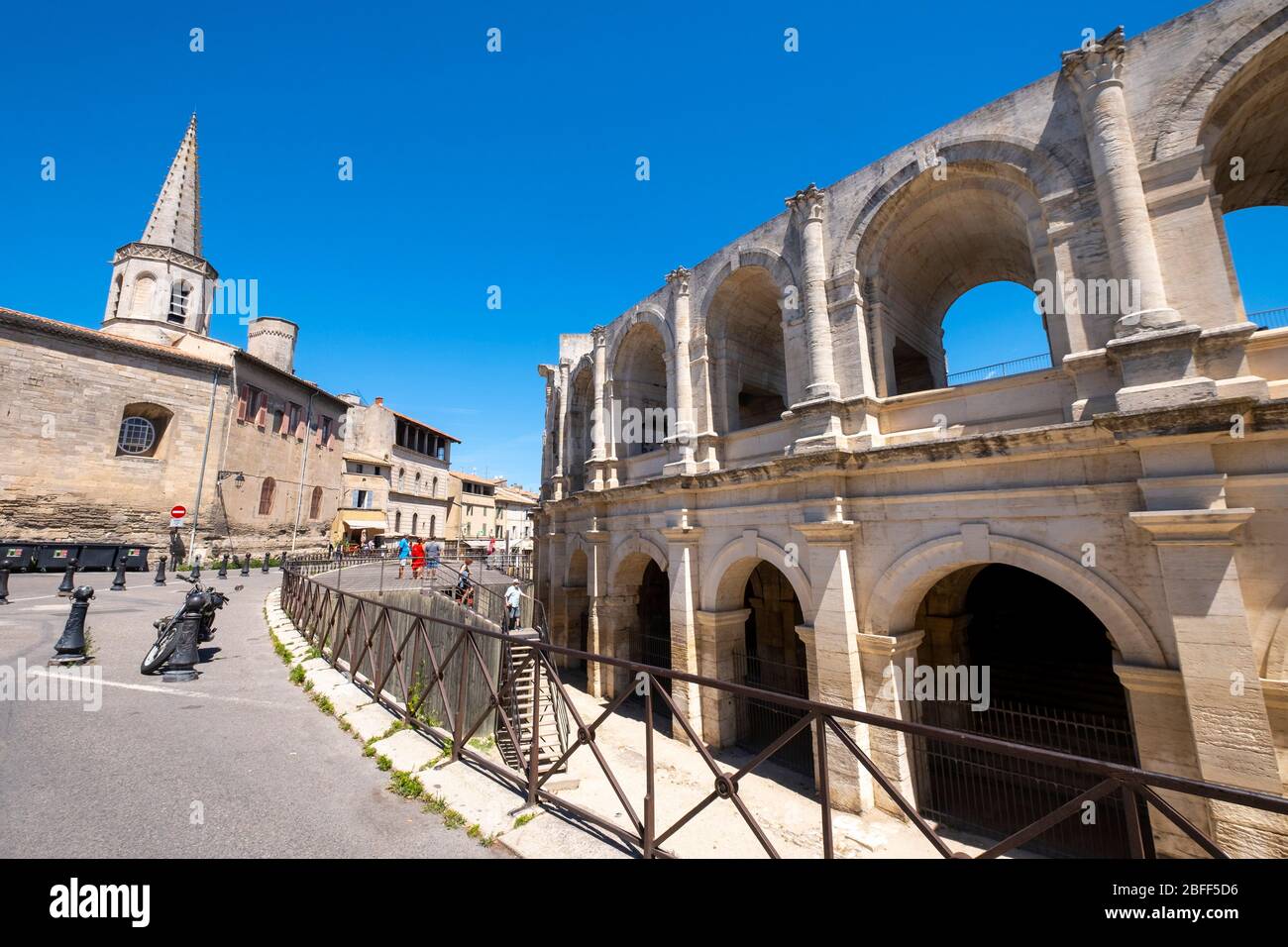 Römisches Amphitheater und der Kirchturm des Église Couvent des Cordeliers in Arles, Frankreich, Europa Stockfoto
