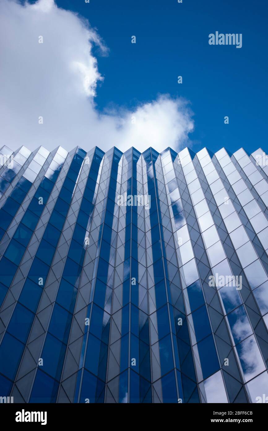 Abstrakte Architekturreflexionen und Winkel gegen einen blauen Himmel, der für Geometrie eingerahmt ist Stockfoto